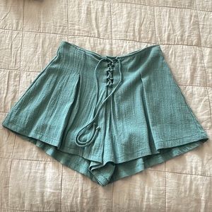 High waisted, teal pleated shorts